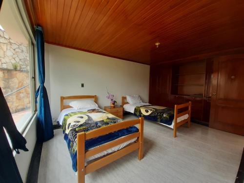 a bedroom with two beds and a window at Lujosa Casa Quinta en Naturaleza Andina in Iza