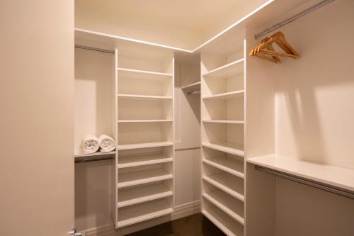 a walk in closet with white shelves at Picture Point Villa in Queenstown
