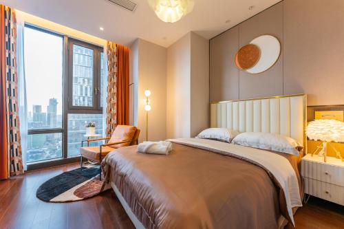 a bedroom with a large bed and a large window at Locals Apartment Place 25 in Hankou