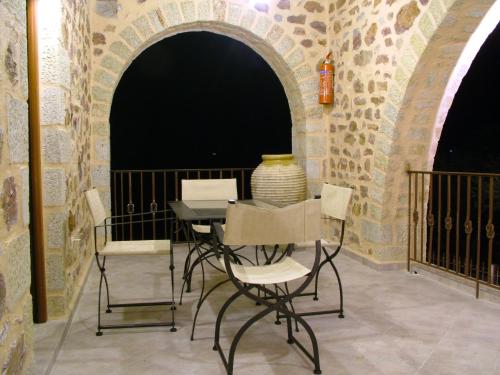 una mesa con sillas y un jarrón sentado en ella en Xenonas Thalis en Skoutarion