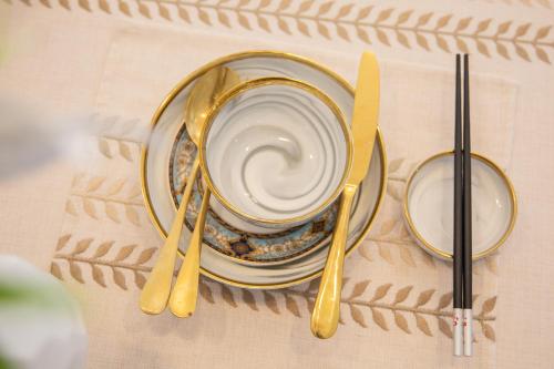 a table with a plate and a cup and two teaspoons at Locals Apartment Inn 04 in Haikou