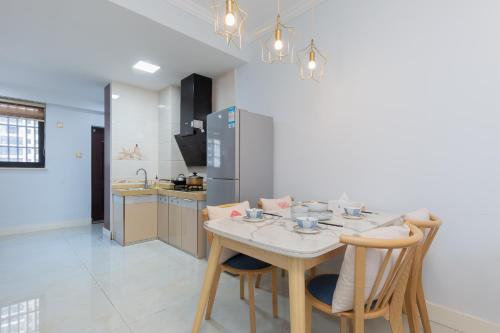 a kitchen with a table and chairs in a room at Locals Apartment Inn 04 in Haikou