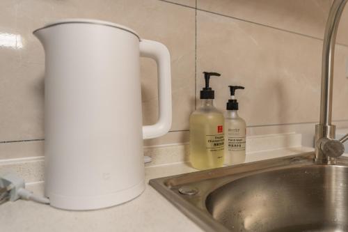 eine Küchentheke mit zwei Flaschen Seife und einem Waschbecken in der Unterkunft Locals Apartment Inn 38 in Jiang'an