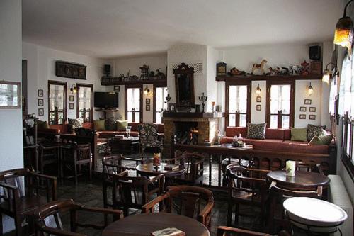 a restaurant with tables and chairs and a fireplace at Hotel Petrino in Makrinitsa