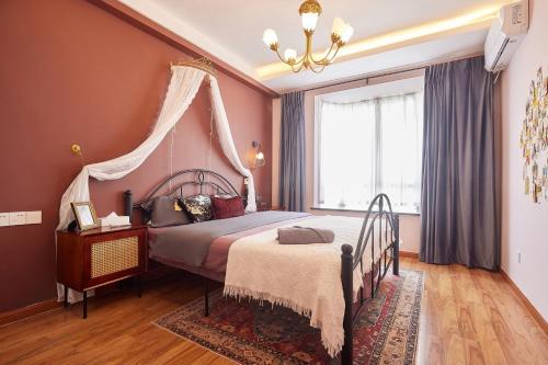 1 dormitorio con cama con dosel y ventana en Locals Apartment House 02, en Changsha