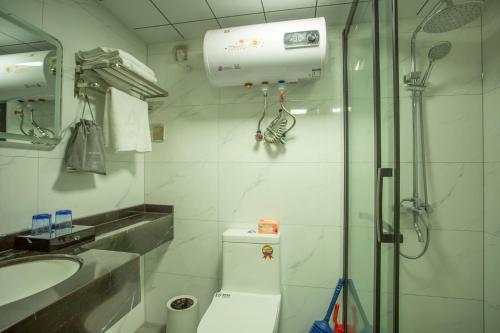 a bathroom with a shower and a toilet and a sink at Locals Apartment Place 44 in Zhanjiang