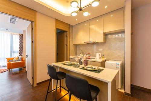 Locals Apartment House 35 في Hankou: مطبخ مع طاولة وكراسي في غرفة