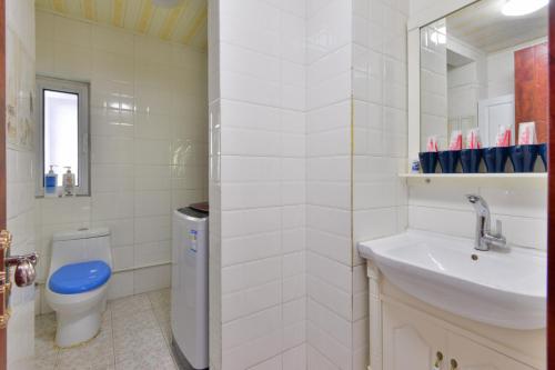 a white bathroom with a toilet and a sink at Locals Apartment House 90 in Tianjin