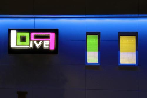 a blue wall with a neon sign on it at B&B Live09 Design in Pisa