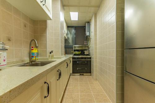 a large kitchen with a sink and a refrigerator at Locals Apartment Inn 01 in Ganzhou