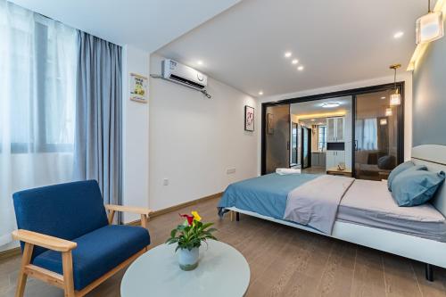 een slaapkamer met een bed, een stoel en een tafel bij Locals Apartment Place 99 in Hangzhou