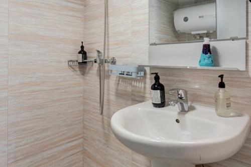 a bathroom with a white sink and a mirror at Locals Apartment House 01 in Zhengzhou