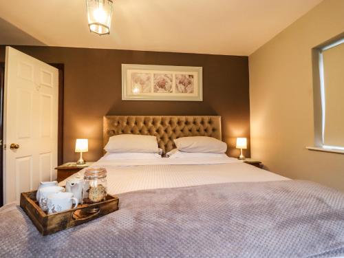 a bedroom with a large bed with two lamps on tables at Baywood Cottage in Keighley