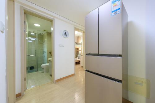 a kitchen with a refrigerator and a walk in shower at Locals Apartment Inn 14 in Tianjin