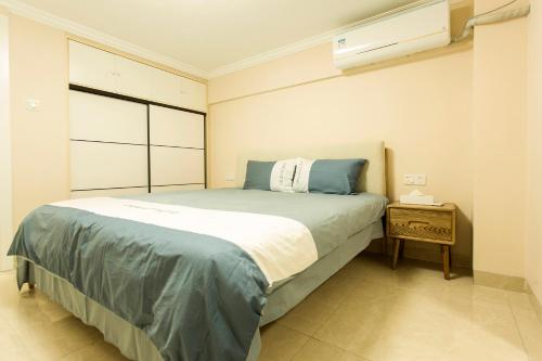een slaapkamer met een groot bed en een raam bij Locals Apartment House 19 in Zhenhai