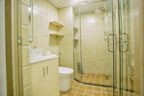 a bathroom with a toilet and a glass shower at Locals Apartment House 19 in Zhenhai