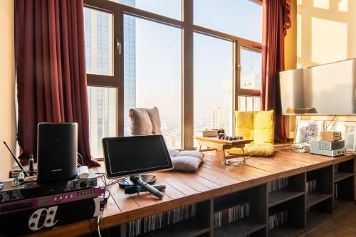 a living room with a desk with a computer on it at Locals Apartment House 00 in Tianjin