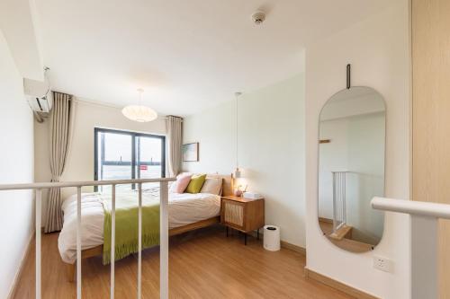 a bedroom with a bed and a mirror at Vanke Apartment Guangzhou South Railway Station Vanke Expo Expo Expo Olympic Park yueshidai square Changlong happy world in Guangzhou