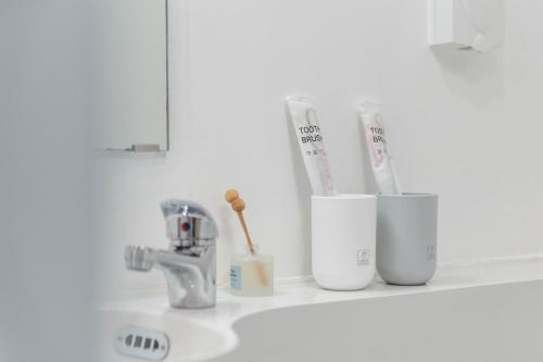 a bathroom counter with toothbrushes and toothpaste at Vanke Apartment Guangzhou South Railway Station Vanke Expo Expo Expo Olympic Park yueshidai square Changlong happy world in Guangzhou