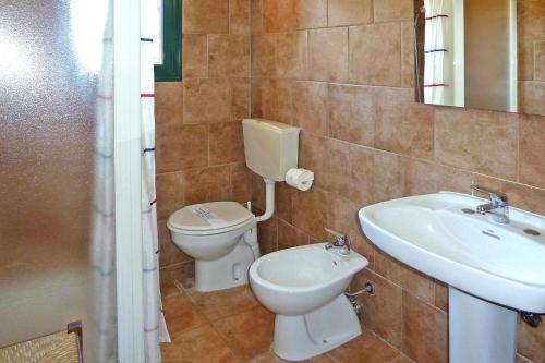 a bathroom with a toilet and a sink at Apartment in the Centra Vacanze il Borgo resort in Guardistallo in Guardistallo