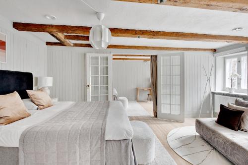コペンハーゲンにあるSanders Secret - Pleasant Three-Bedroom Townhouse Near Main Attractionsの白いベッドルーム(大型ベッド1台、ソファ付)