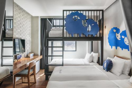 曼谷的住宿－曼谷素里翁可可特爾酒店，一间卧室配有两张双层床和一张书桌