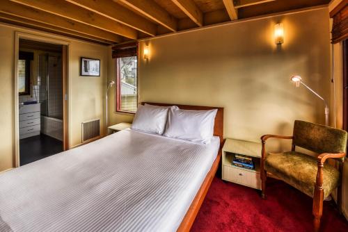 een kleine slaapkamer met een bed en een stoel bij Gundanora in Mount Hotham