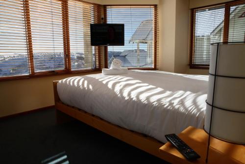 a bedroom with a bed and a tv and windows at Cobungra in Mount Hotham