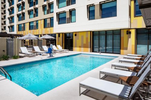 a swimming pool with lounge chairs and a building at Hyatt Place Scottsdale North in Scottsdale
