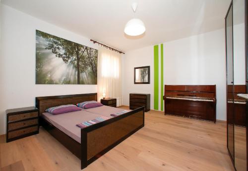 a bedroom with a bed and a piano at Beach Apartments in Senj
