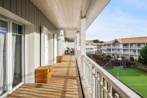 - un balcon avec un court de tennis dans un bâtiment dans l'établissement Appartement des Asphodèles - Welkeys, à La Teste-de-Buch