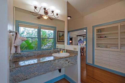 a bathroom with a sink and a large window at Poipu Plantation Vacation Rentals in Koloa