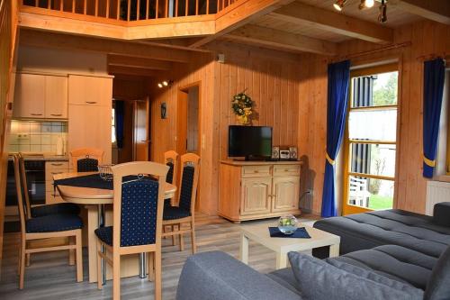 ein Wohnzimmer mit einem Esstisch und einer Küche in der Unterkunft Ferienhaus Nr 6D, Feriendorf Hagbügerl, Bayr Wald in Waldmünchen