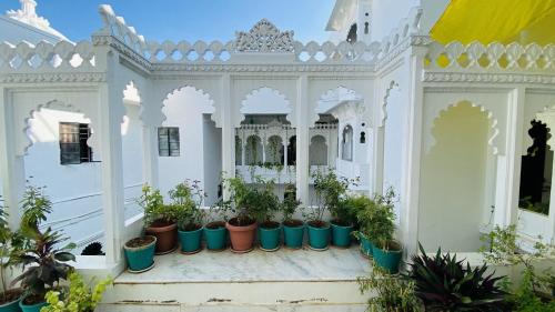 a white house with potted plants in it at Kotra Haveli A Boutique Hotel by Lake Pichola in Udaipur