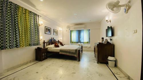 a bedroom with a bed and a window at Kotra Haveli A Boutique Hotel by Lake Pichola in Udaipur