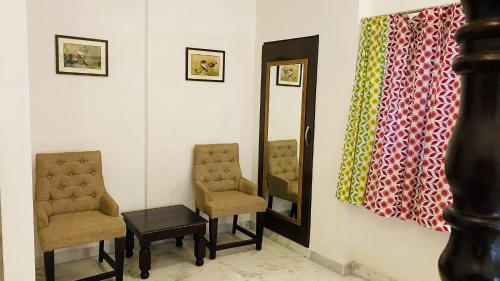 two chairs and a mirror in a room at Kotra Haveli A Boutique Hotel by Lake Pichola in Udaipur