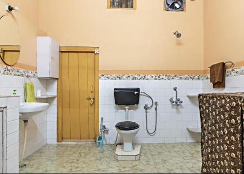 a bathroom with a toilet and a sink at Garden Cottages in Shimla