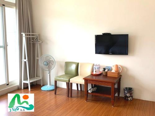 a living room with a chair and a table with a fan at 3520 Homestay in Taitung City