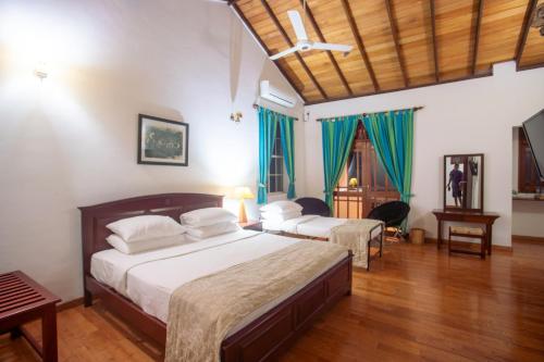 1 dormitorio con 2 camas y suelo de madera en The Kandyan Villa, en Kandy