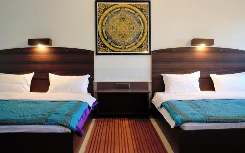 a room with two beds and a picture on the wall at Shivir Aranya - Wilderness Resort in Alwar