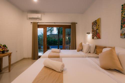 1 Schlafzimmer mit 2 Betten und einem Fenster in der Unterkunft Mag Canggu Bali By Hospitality Bali in Canggu