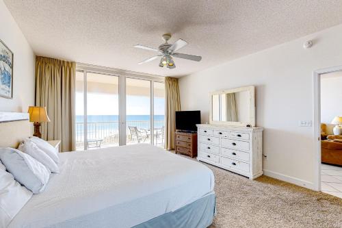 a bedroom with a bed and a television and a balcony at Navarre Beach Regency 308 in Navarre