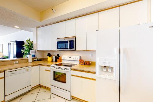 a kitchen with white cabinets and a refrigerator at Navarre Beach Regency 308 in Navarre