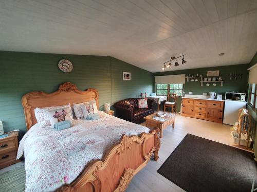 a bedroom with a large bed and a kitchen at Marshland Alpacas Glamping Lodge in New Holland