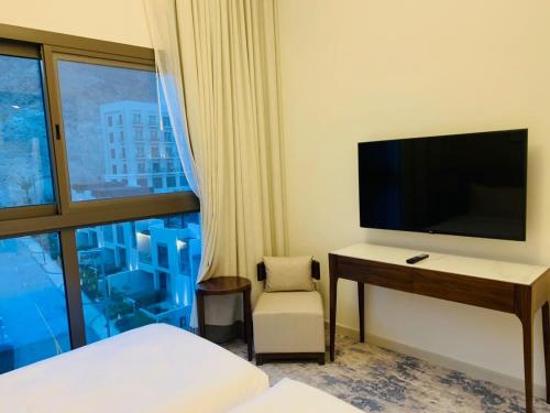 a hotel room with a desk with a tv and a window at luxury sea view Address Hotel apartment Fujairah in Fujairah