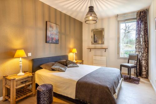 a bedroom with a large bed and a window at Le Clos Bellevue Appartement T3 parking + piscine in Rodez