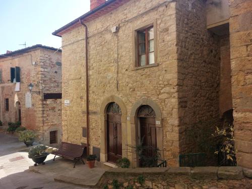 un bâtiment en pierre avec un banc devant lui dans l'établissement Belvilla by OYO Vista dalla Terrazza, à Montecastelli