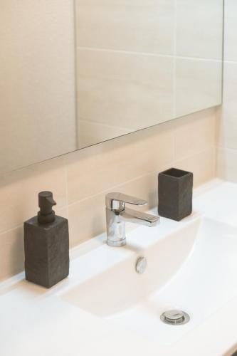 a bathroom sink with a faucet and a mirror at Le Clos Bellevue Appartement T3 parking + piscine in Rodez