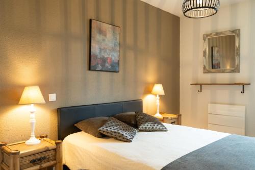 a bedroom with a bed with two night stands and two lamps at Le Clos Bellevue Appartement T3 parking + piscine in Rodez