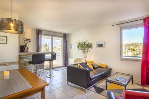 a living room with a couch and a table at Le Clos Bellevue Appartement T3 parking + piscine in Rodez